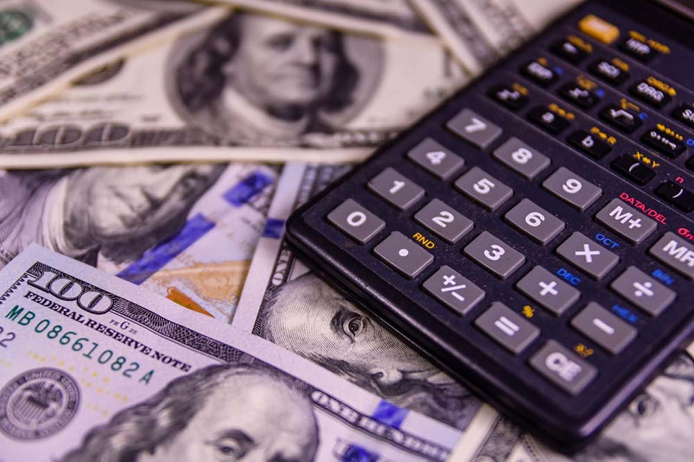 calculator-cash A calculator atop a pile of cash