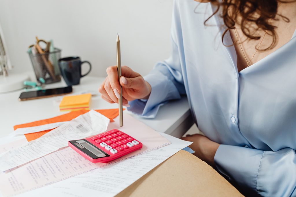A woman uses a calculator to figure damages based on medical bills and receipts